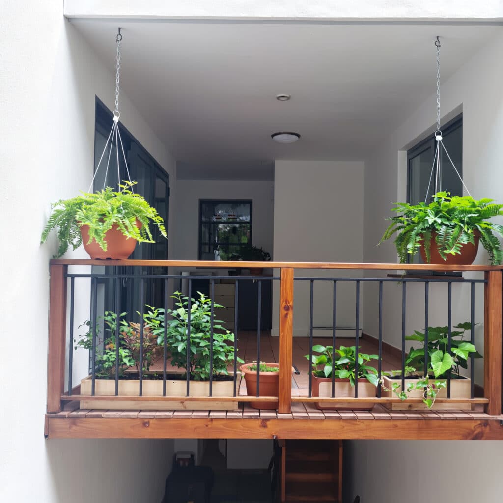 Jardim suspenso rústico com pallets e vasos de barro.