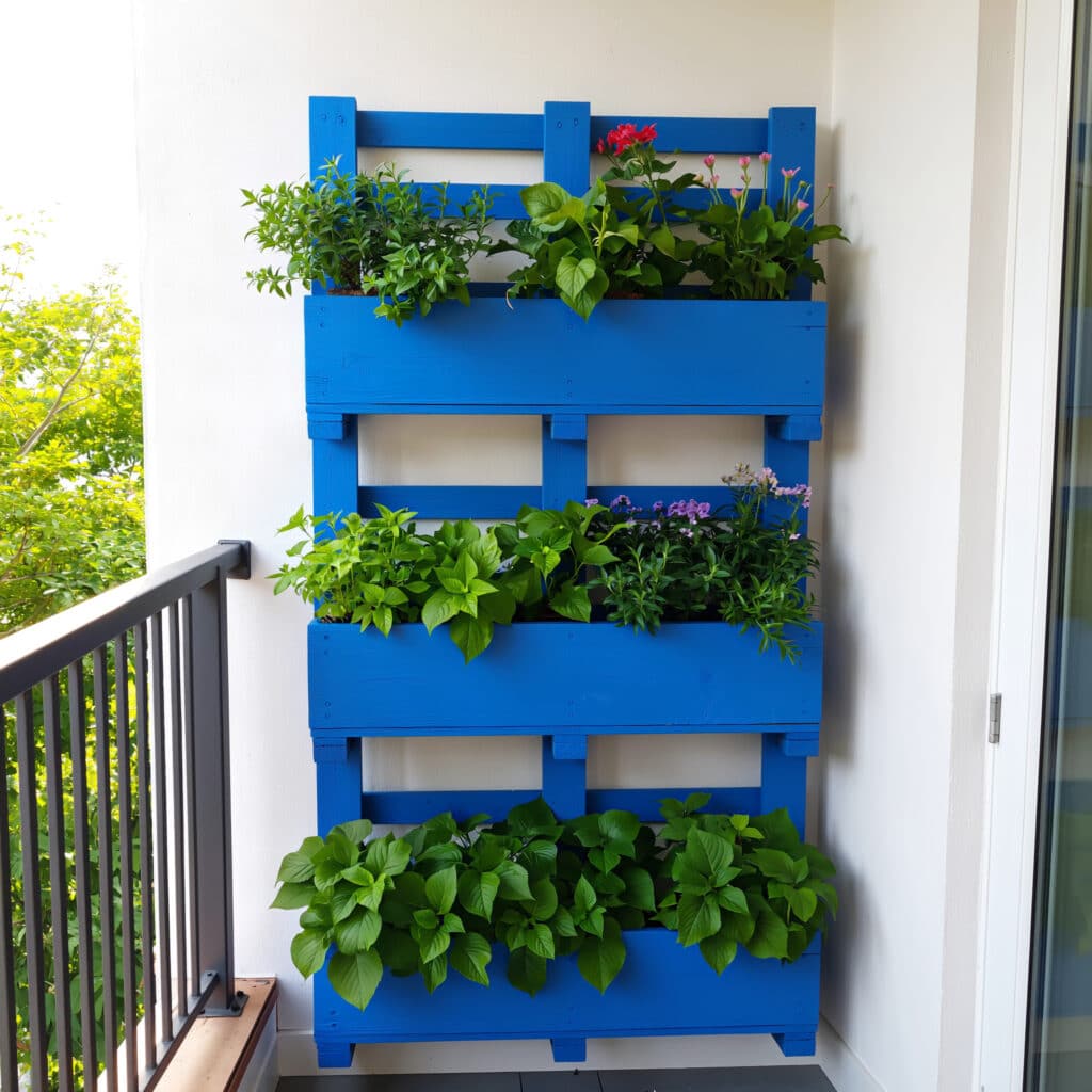 Paletes pintados com plantas em jardim vertical externo